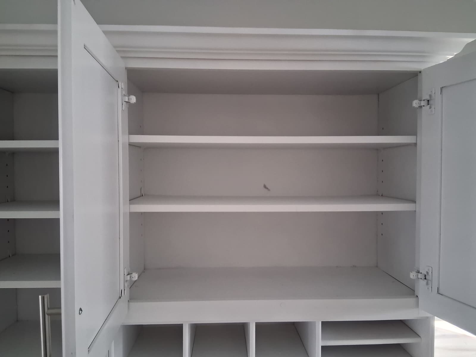 Move-out cleaning with detailed care inside kitchen cabinets and shelves, ensuring dust-free and sanitized storage areas