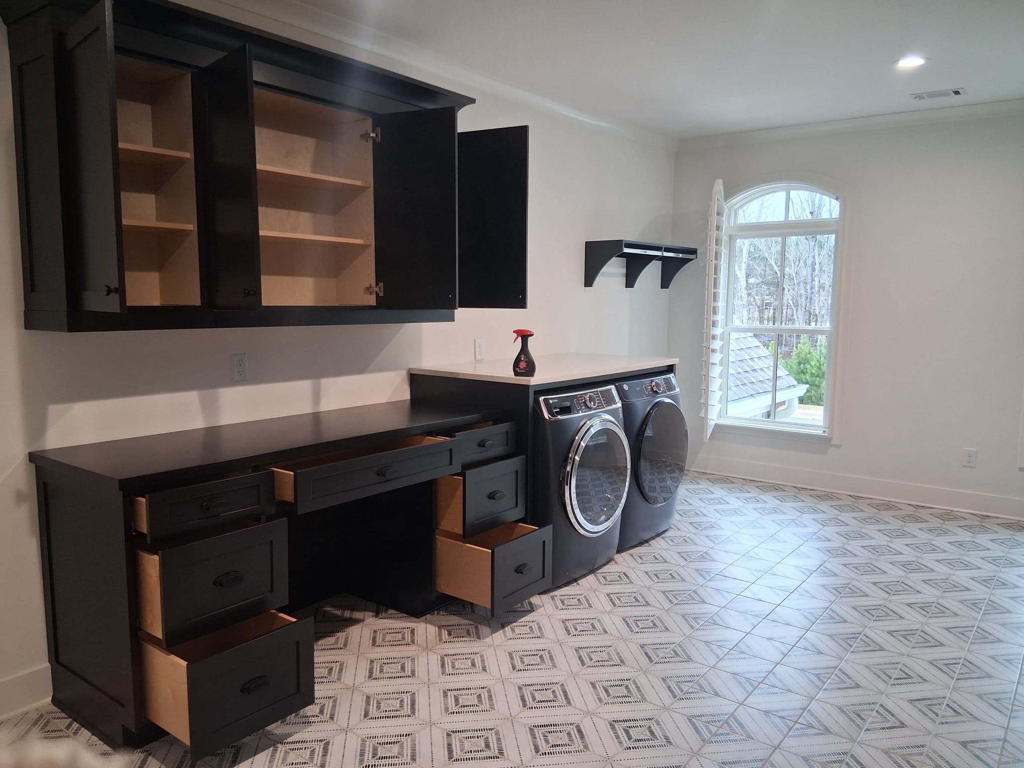 Move-out cleaning of laundry room from another angle, highlighting cabinets, countertops, and appliance area