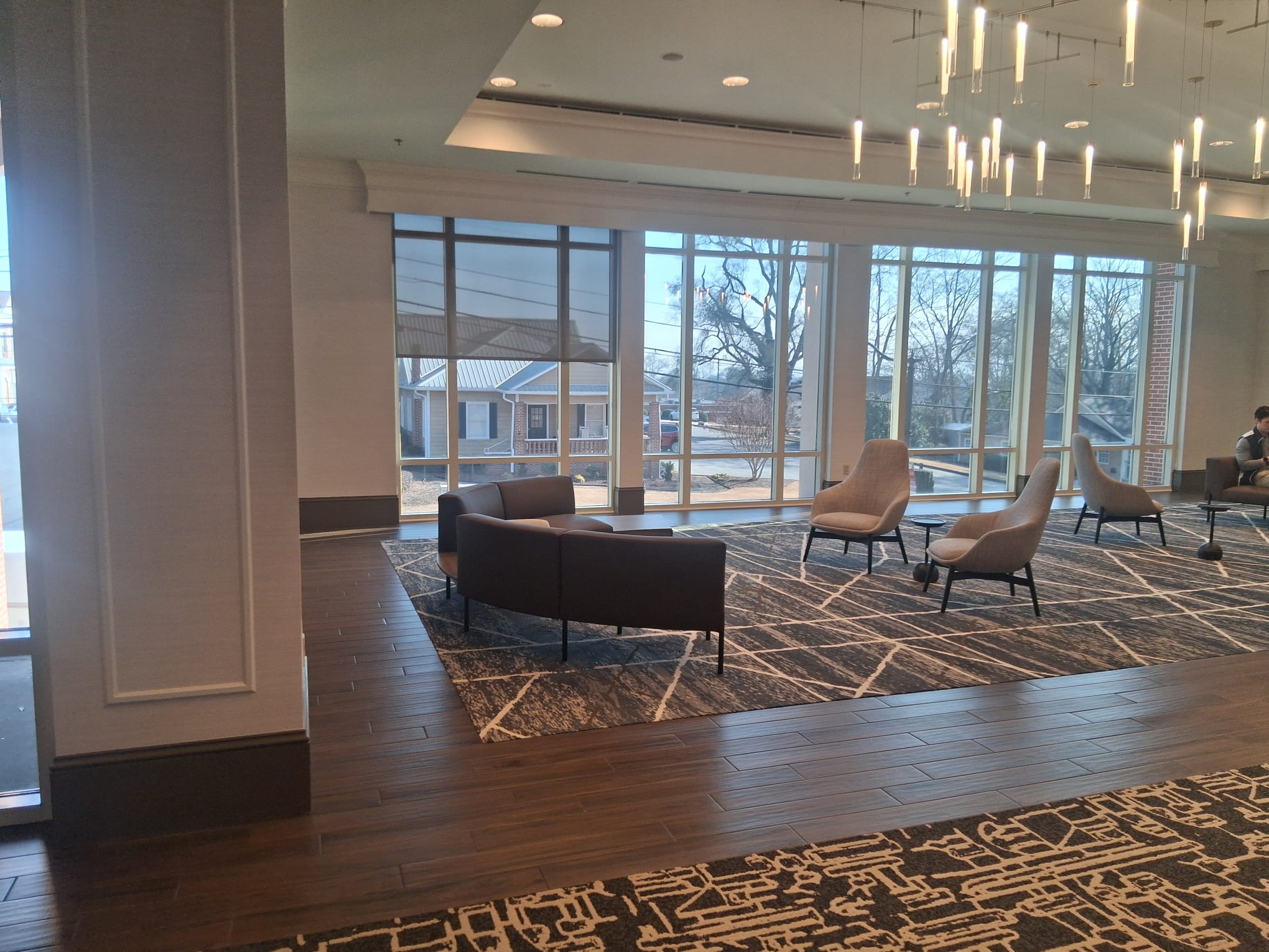 Regular cleaning of a modern office lounge with seating area, clean floors, carpets, and large windows