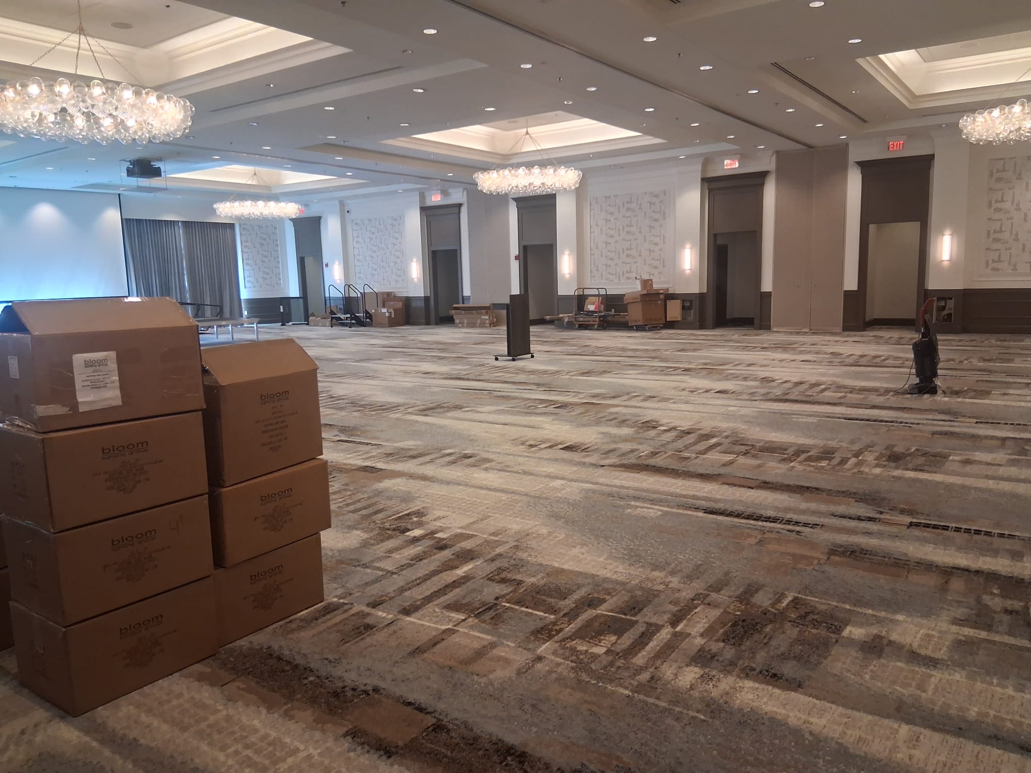 Regular cleaning of a large conference hall with carpeted floors, organized space, and clear walkways