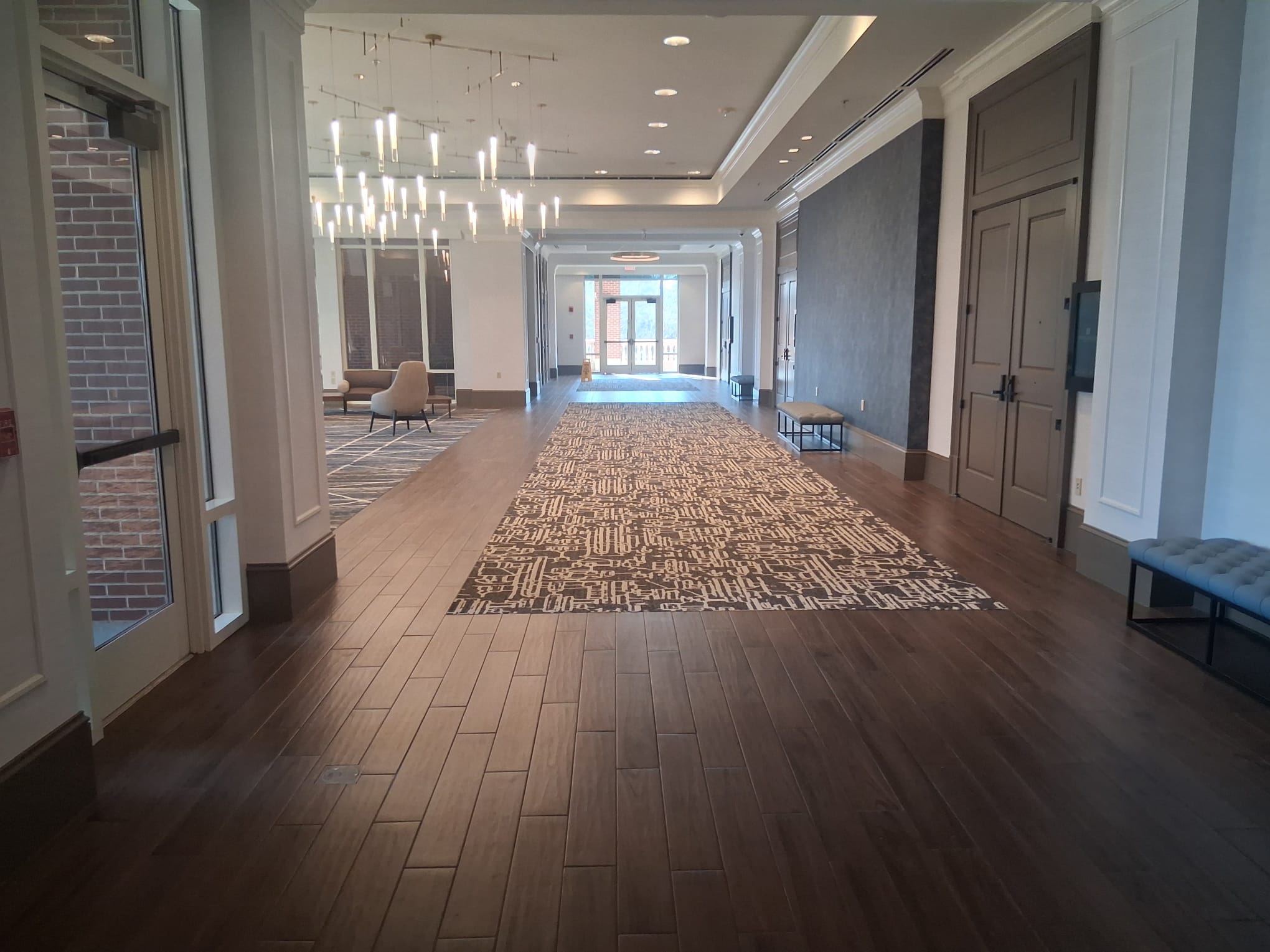 Regular cleaning of an office lobby corridor with wood floors, carpet runner, and clean high-traffic walkways
