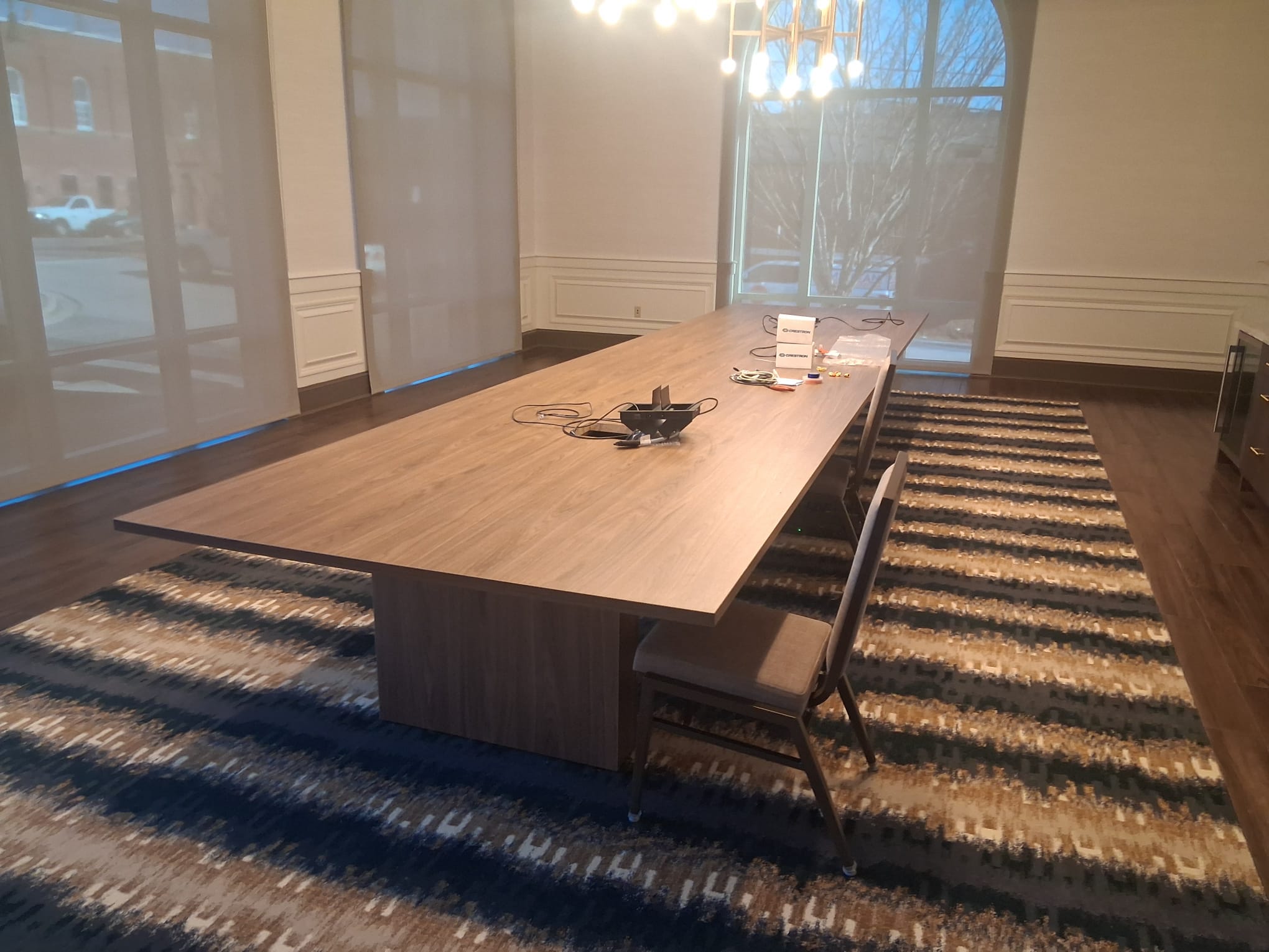 Regular cleaning of an office conference room with meeting table, chairs, carpeted floor, and clean work surfaces