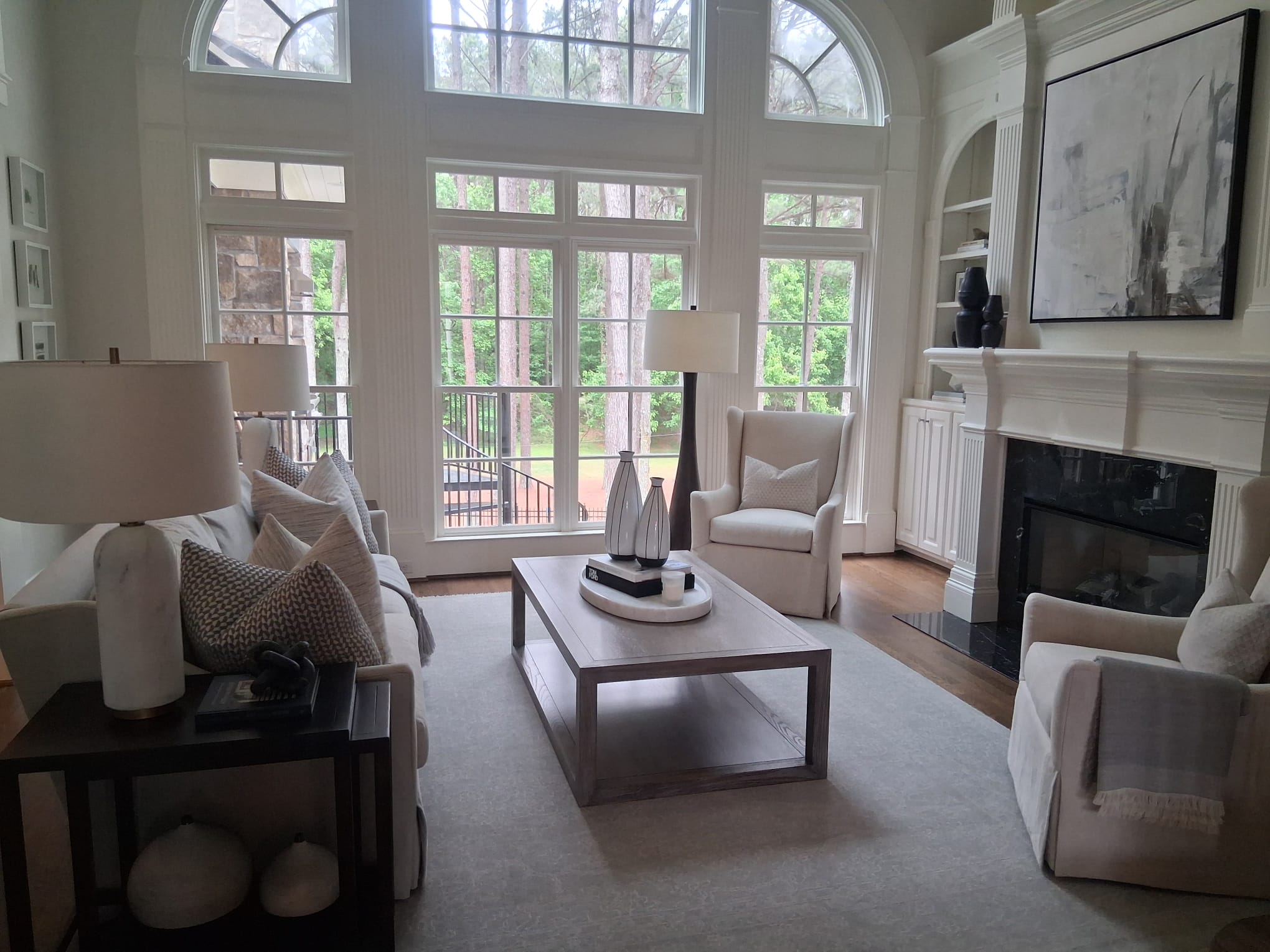Regular cleaning of a luxury living room with large windows, fireplace, furniture, and organized common areas
