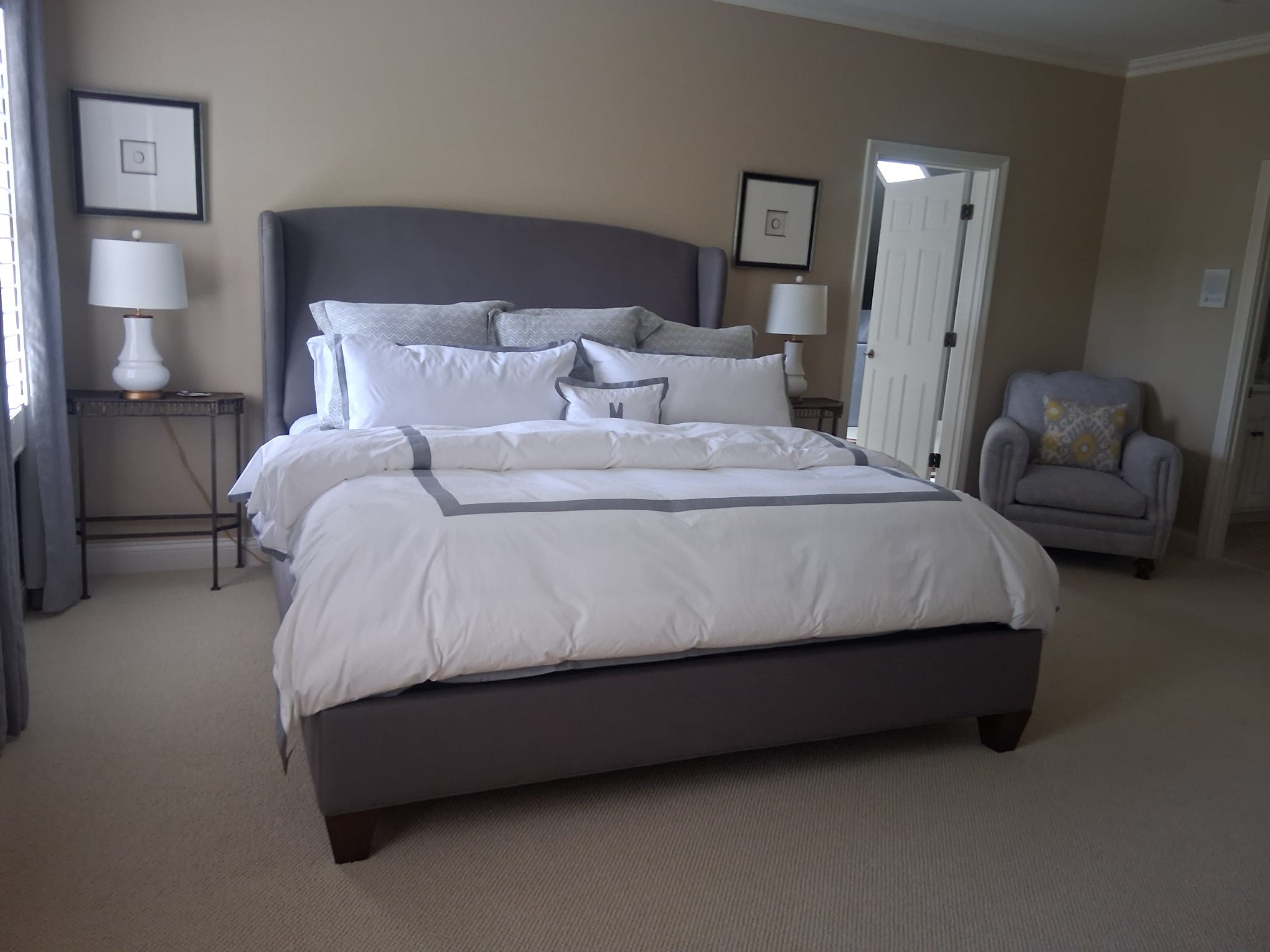 Clean and organized bedroom after regular house cleaning with freshly made bed and carpeted floor