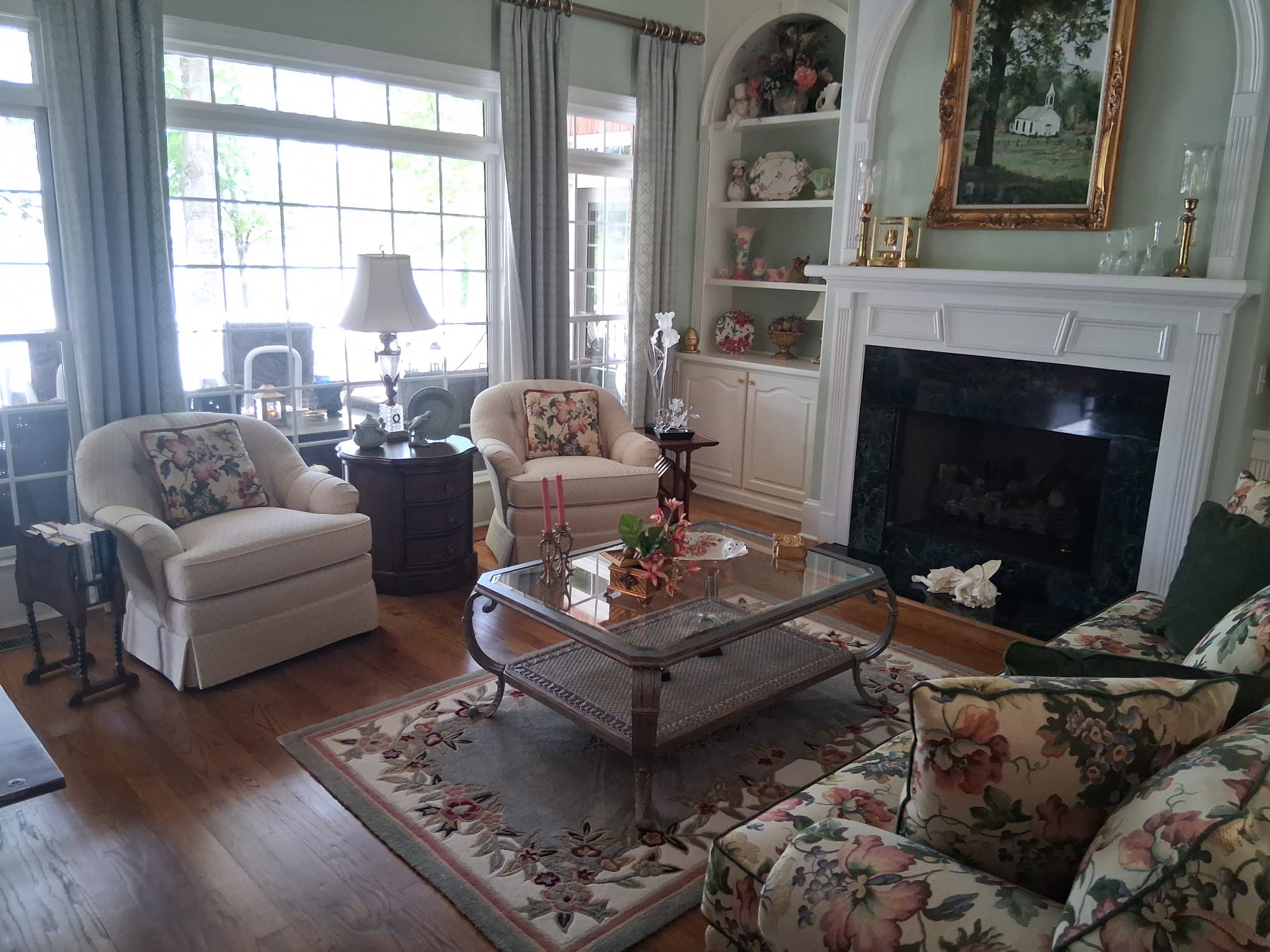 Regular living room cleaning with fireplace, built-in shelves, sofas, furniture, hardwood floors, and large windows
